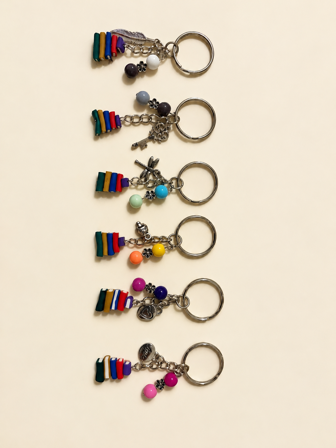 Collection view of six book-stack keychain designs; each listing includes one keychain only