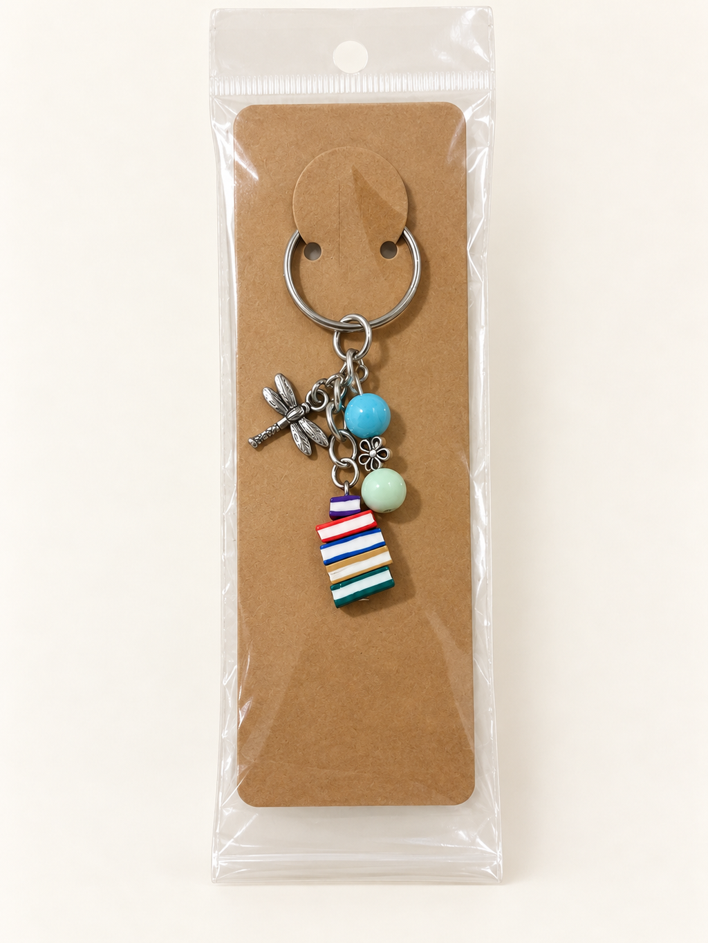 Dragonfly Book Stack Keychain on a kraft card in a clear sleeve