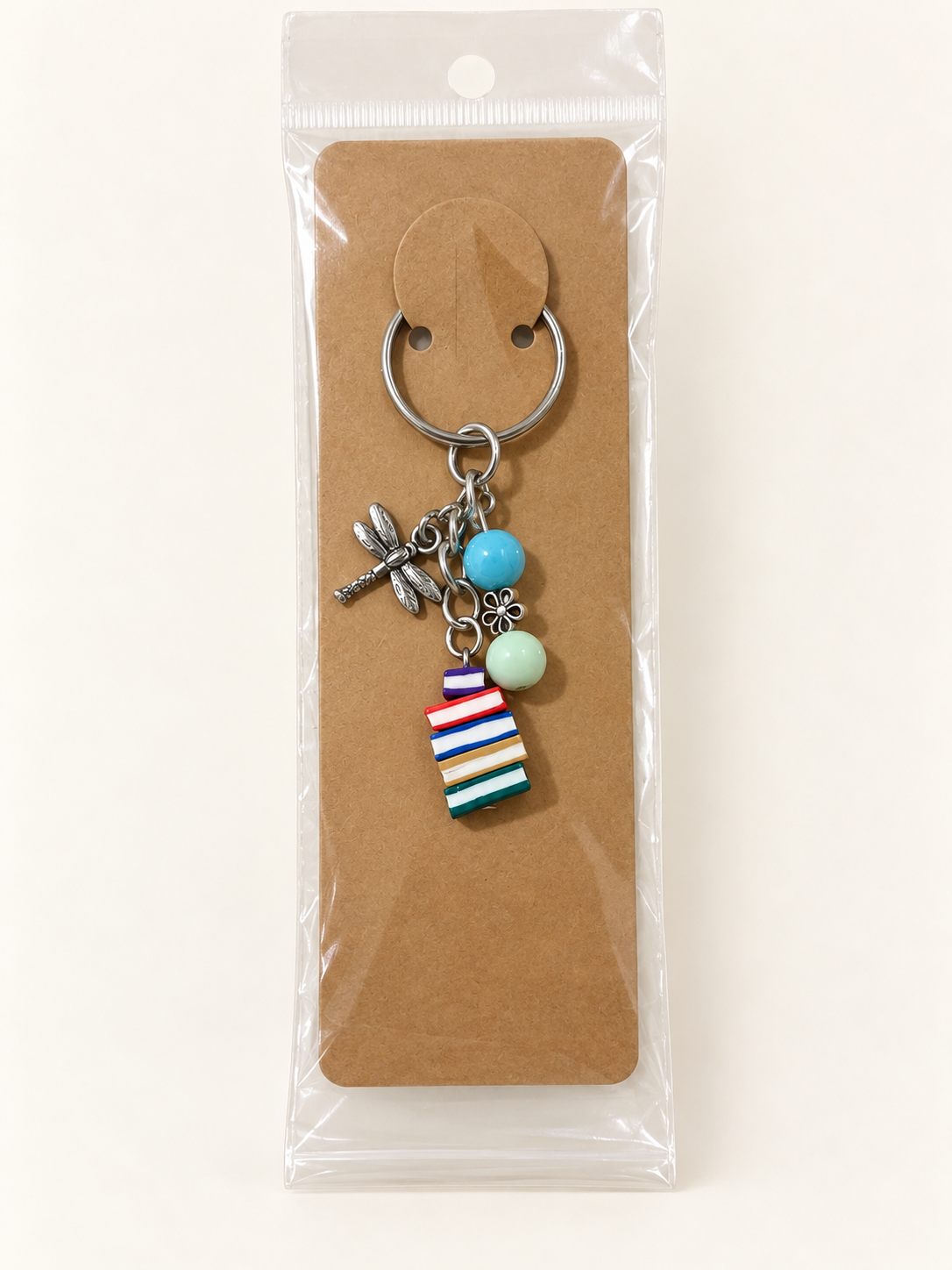 Dragonfly Book Stack Keychain on a kraft card in a clear sleeve