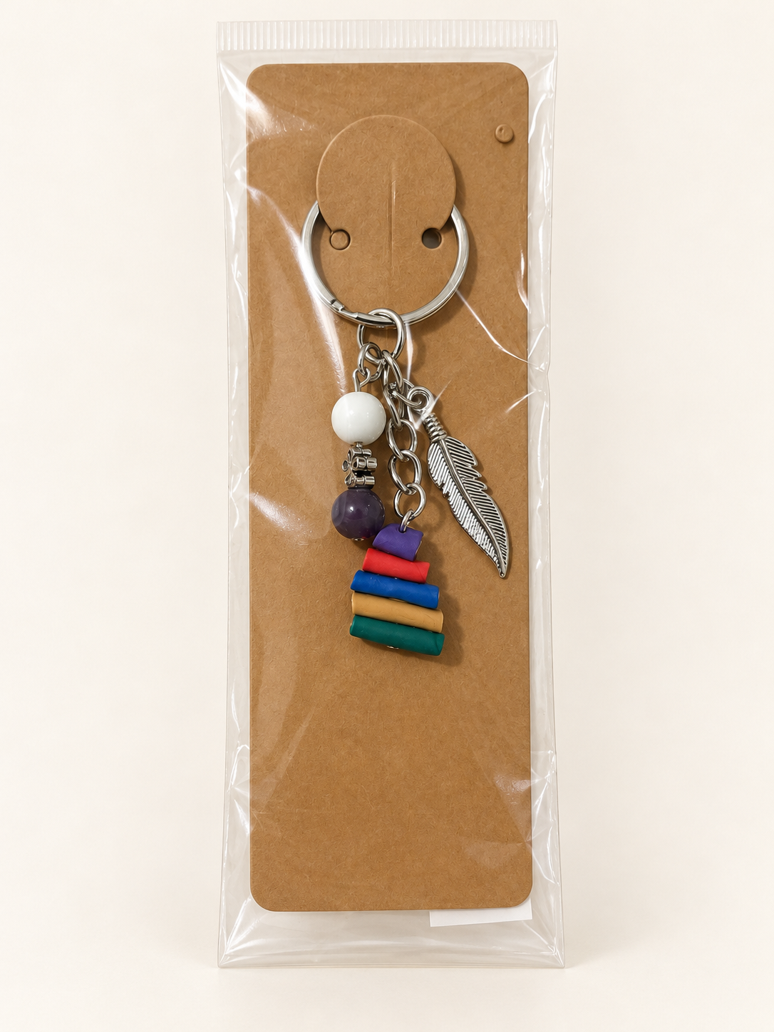 Feathered Book Stack Keychain on a kraft card in a clear sleeve