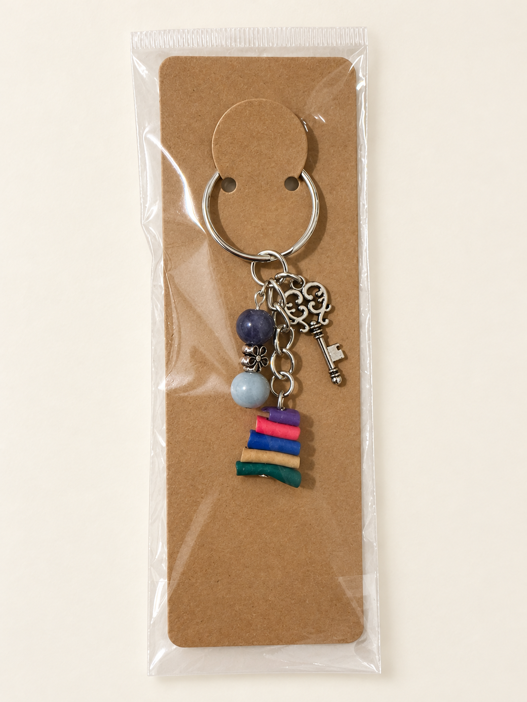 Vintage Key Book Stack Keychain on a kraft card in a clear sleeve