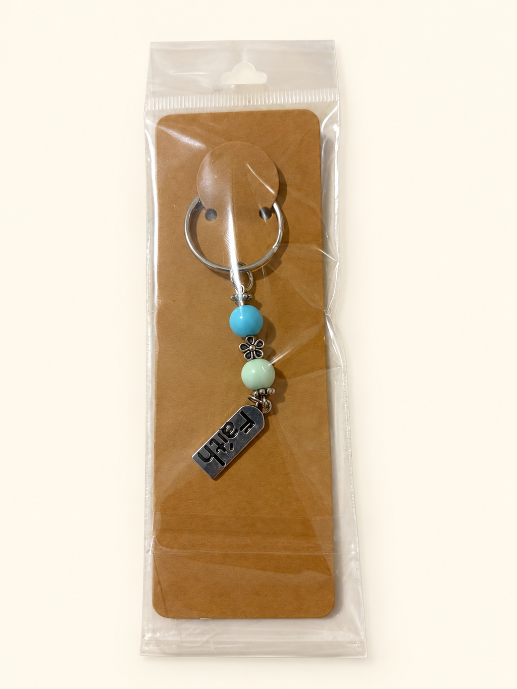 Faith Word Bead Keychain with turquoise and pale mint beads, packaged on a kraft card in a clear sleeve